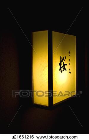 Stock Photograph - Illuminated nameboard, side view, black background, Japan. Fotosearch