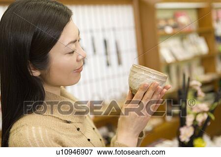 Woman holding a Japanese cup in the shop of hotel, side view, Japan, differential focus View Large Photo Image Stock Photo - Woman holding a Japanese cup in the shop of hotel, side view, Japan, differential focus. Fotosearch