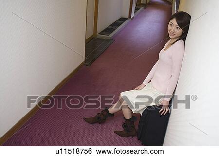Young woman sitting on a suitcase in the corridor of hotel, side view, high angle view, Japan View Large Photo Image Stock Photograph - Young woman sitting on a suitcase in the corridor of hotel, side view, high angle view, Japan. Fotosearch