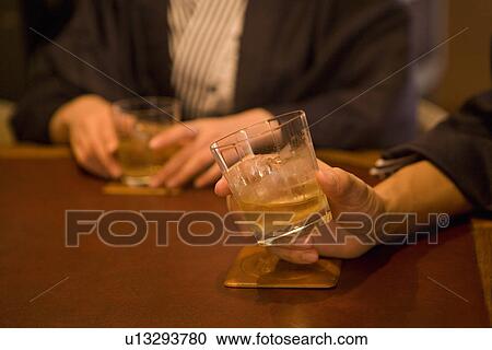 Stock Image - Japanese couple in Yukata drinking at the hotel bar, front view, side view, differential focus, Japan. Fotosearch