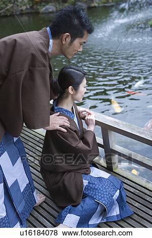 Japanese couple in Yukata looking at the carps in pond, side view, Japan View Large Photo Image Stock Photo - Japanese couple in Yukata looking at the carps in pond, side view, Japan. Fotosearch