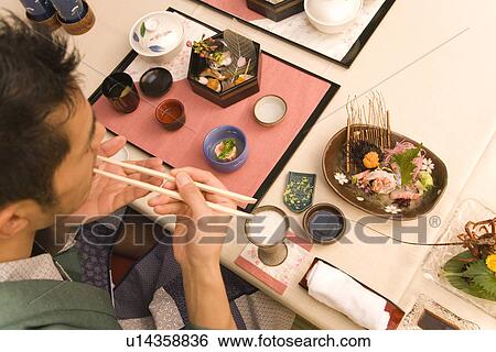 Stock Photograph - Man in Yukata having dinner, high angle view, Japan. Fotosearch