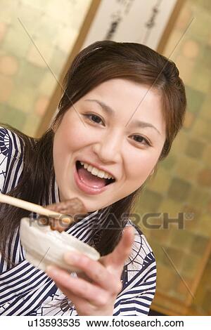 Portrait of a woman holding slice of beef with chopsticks, front view, Japan View Large Photo Image Stock Photography - Portrait of a woman holding slice of beef with chopsticks, front view, Japan. Fotosearch