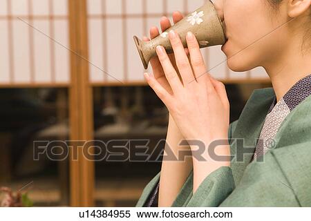 Stock Photography - Woman in Yukata drinking beer, side view, Japan. Fotosearch