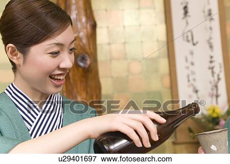 Woman smiling and pouring beer, front view, Japan View Large Photo Image Stock Photo - Woman smiling and pouring beer, front view, Japan. Fotosearch