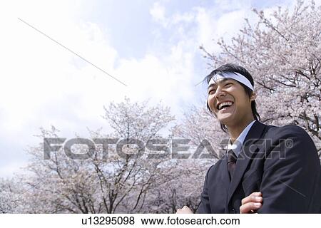 Stock Photo - Businessman Standing With Crossing Arms, Low Angle View, Head and Shoulder, Copy Space. Fotosearch
