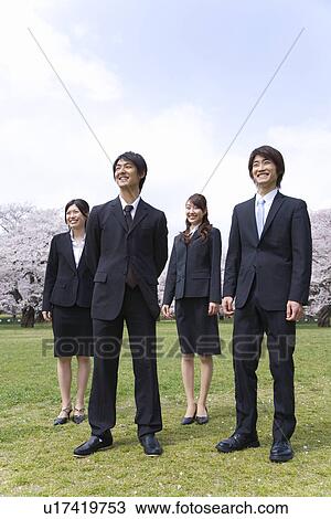 Stock Image - Businessmen and Businesswomen in Field, Front View, Full Length. Fotosearch