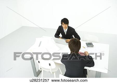 Stock Photo - Businessmen In Meeting, High Angle View. Fotosearch
