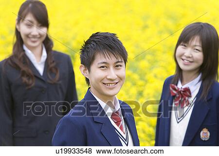 Stock Photo - Businesswoman and Students Standing in Rape Field, Side View, Head and Shoulder, Differential Focus. Fotosearch