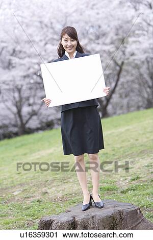 Stock Image - Businesswoman Holding a White Board, Full Length, Front View. Fotosearch