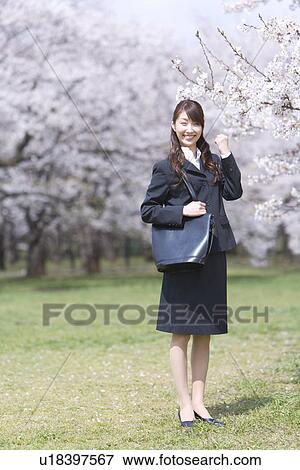 Stock Photo - Businesswoman Standing in the Field With Her Fist in the Air, Smiling, Full Length, Portrait, Front View. Fotosearch