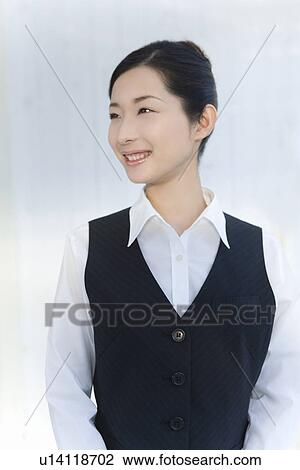 Stock Image - Portrait of a woman in office, looking away, front view, white background. Fotosearch