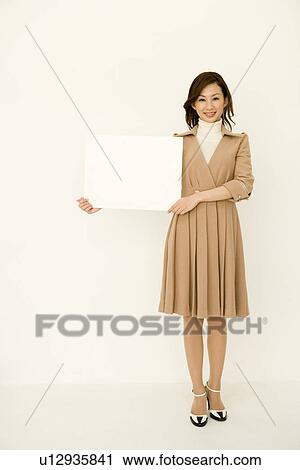 Portrait of a woman smiling and holding a blank board, looking at camera, front view, white background View Large Photo Image Stock Image - Portrait of a woman smiling and holding a blank board, looking at camera, front view, white background. Fotosearch