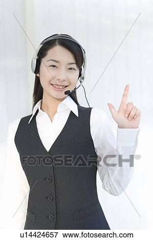 Portrait of a woman wearing hands-free headset, looking at camera, front view View Large Photo Image Stock Photo - Portrait of a woman wearing hands-free headset, looking at camera, front view. Fotosearch