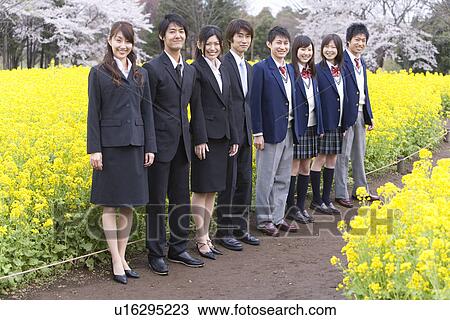 Stock Image - Students and New Business People Standing in a Line, Side View, Full Length. Fotosearch