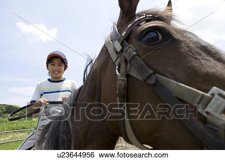 Stock Photograph - Boy riding a horse. Fotosearch