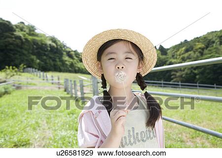 Stock Photo - Girl blowing dandelion . Fotosearch