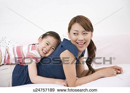 Stock Photo - Mother and daughter on sofa. Fotosearch