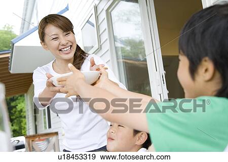 Son handing a bowl to mother View Large Photo Image Stock Photo - Son handing a bowl to mother. Fotosearch