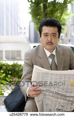 Stock Photo - Businessman reading newspaper. Fotosearch
