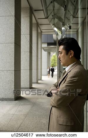 Stock Photo - Businessman standing with arms crossed. Fotosearch