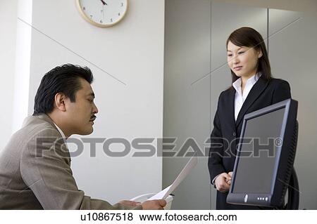 Stock Photo - Businessman talking to colleague. Fotosearch