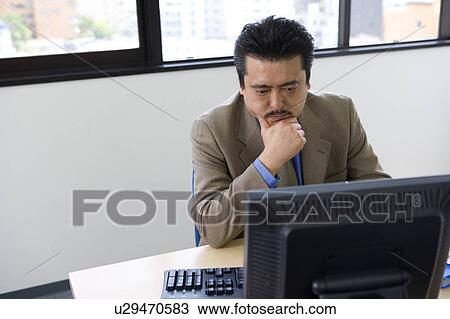 Stock Image - Businessman with hand on chin. Fotosearch