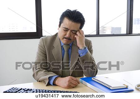 Stock Photo - Businessman with hand on forehead. Fotosearch
