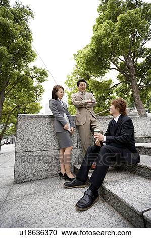 Stock Image - Three business people talking. Fotosearch