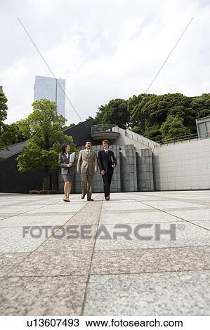 Stock Image - Three business people walking. Fotosearch