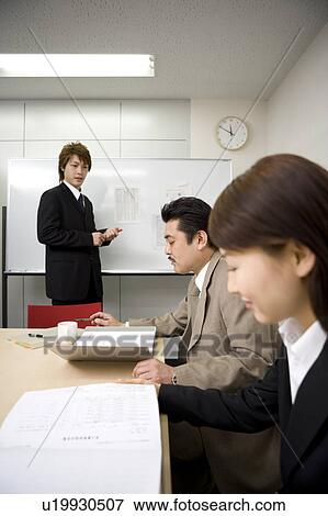 Stock Photo - Three people discussing in meeting room. Fotosearch