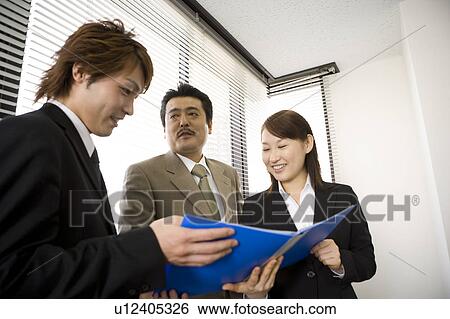 Stock Photograph - Three people talking in office. Fotosearch