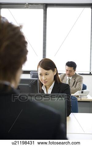 Stock Image - Three people working in office. Fotosearch