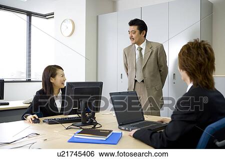 Stock Photograph - Three people working in office. Fotosearch