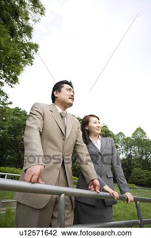 Stock Image - Two business people standing. Fotosearch
