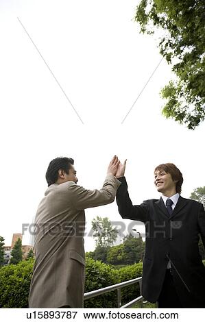 Two businessmen doing high-five View Large Photo Image Stock Photo - Two businessmen doing high-five. Fotosearch