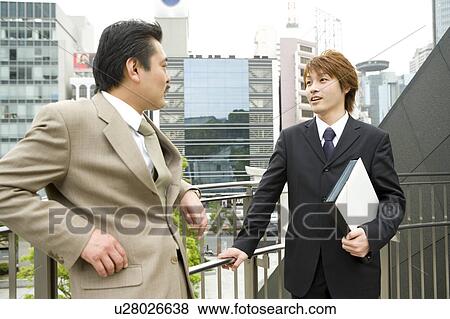 Stock Photo - Two businessmen talking. Fotosearch
