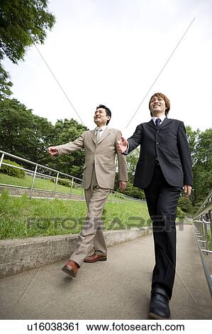 Stock Image - Two businessmen walking. Fotosearch