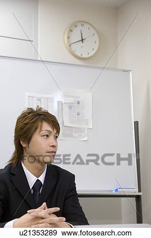 Young businessman sitting in meeting room View Large Photo Image Stock Photo - Young businessman sitting in meeting room. Fotosearch