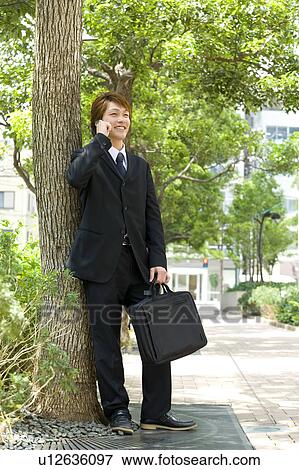 Stock Photo - Young businessman talking over mobile phone. Fotosearch