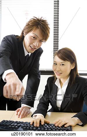Young man and woman working in office View Large Photo Image Stock Image - Young man and woman working in office. Fotosearch