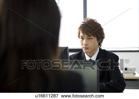 Stock Photo - Young man working in office. Fotosearch