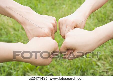 Stock Photography - Fists of four people. Fotosearch