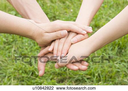 Stock Image - People stacking hands on top of each other. Fotosearch