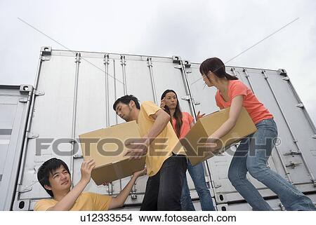 Picture - Young people carrying boxes. Fotosearch