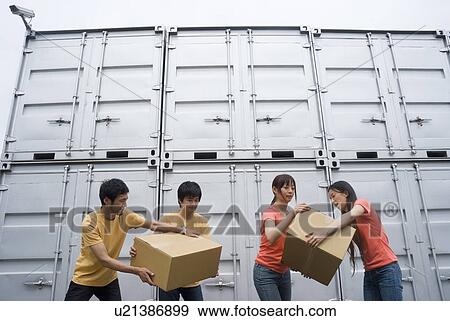 Stock Photo - Young people carrying boxes. Fotosearch