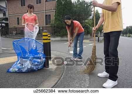 Picture - Young people cleaning garbage. Fotosearch