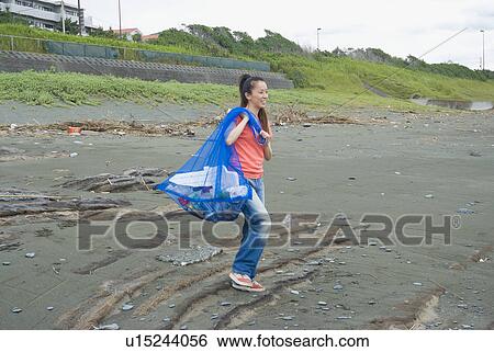 Young woman carrying garbage bag View Large Photo Image Stock Photograph - Young woman carrying garbage bag. Fotosearch