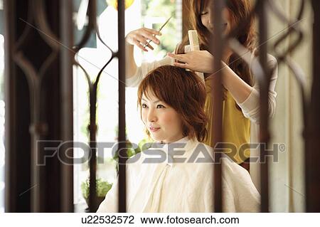 Stock Image - Hairdresser cutting woman's hair. Fotosearch