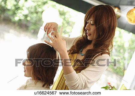 Stock Photo - Hairdresser cutting woman's hair. Fotosearch